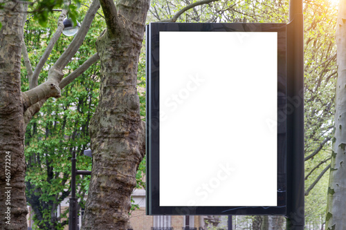 Billboard Mockup in a city with natural landscape. Parisian style hoarding advertisement on a pole close to a park