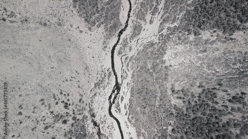 Storm, snowfall in the huge glacier of Mount Belukha, the valley of the Aktru River, the Altai Mountains. Cloudy weather, stone in the snow, storm, wildlife, winter forest, frozen mountain river in