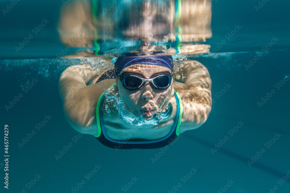 Female swimmer at the swimming pool.Underwater image.
