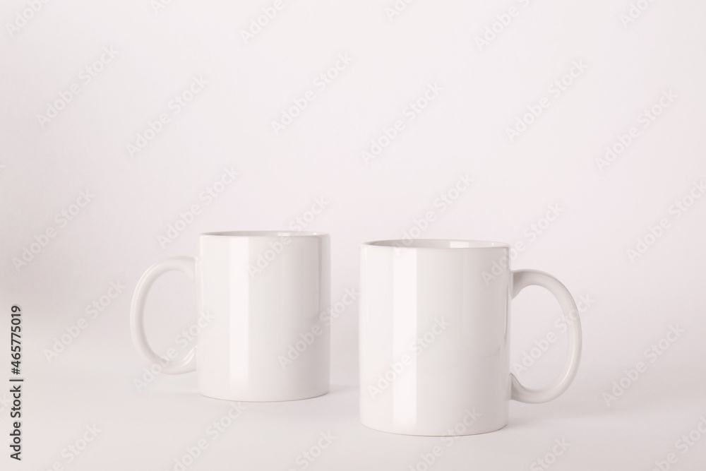 Blank white ceramic mugs on light background Blank white ceramic mugs on light background