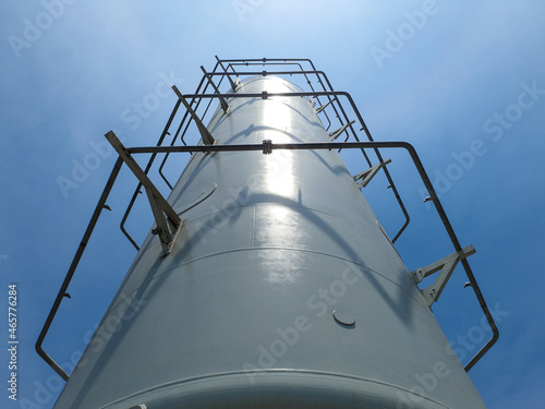 Vertical LNG Cryogenic Tank with clear blue sky background