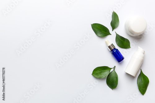 Organic cosmetic products with green leaves on white background. Copy space, flat lay