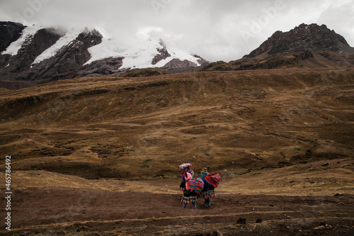 colorful cultural women walking across the andes in Peru 