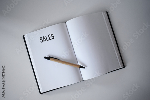 Book with pen on desk with sales heading