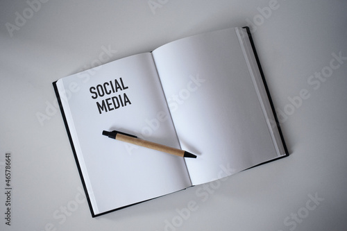 Book with pen on desk with social media heading