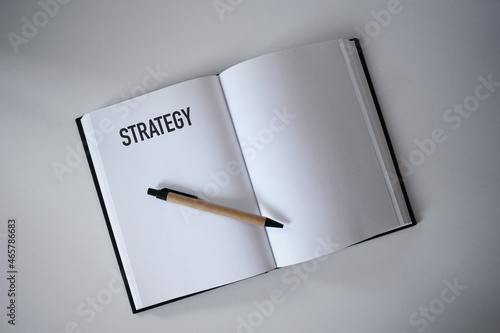 Book with pen on desk with strategy heading