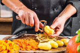 Mann schält Kartoffeln zur Vorbereitung eines leckeren Gerichts.