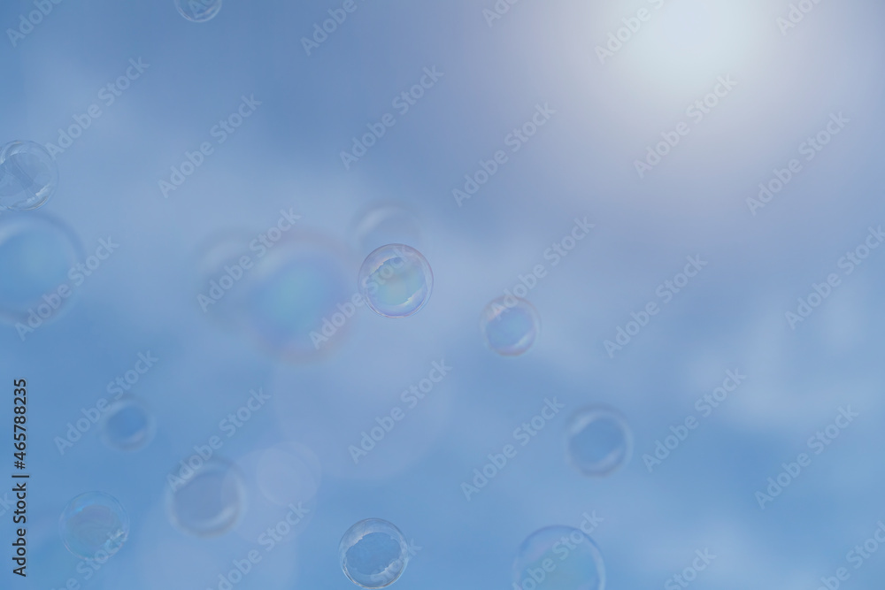 Bubbles floating in sunlight on a blue sky