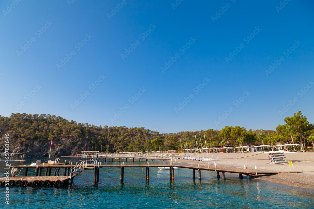 Empty wooden pier over the sea shore with copy space near the hotel in touristic place in turkey, camyuva.