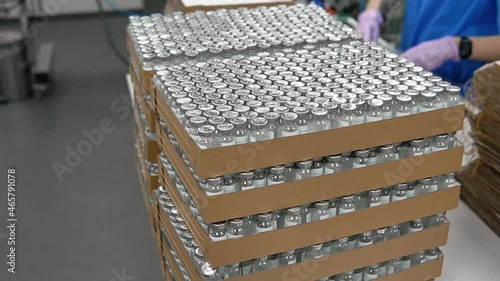 Medicine bottles are getting packed into boxes. Drugs in bottles into a box. ampoules with medicine vaccine in boxes. Production of medicines.