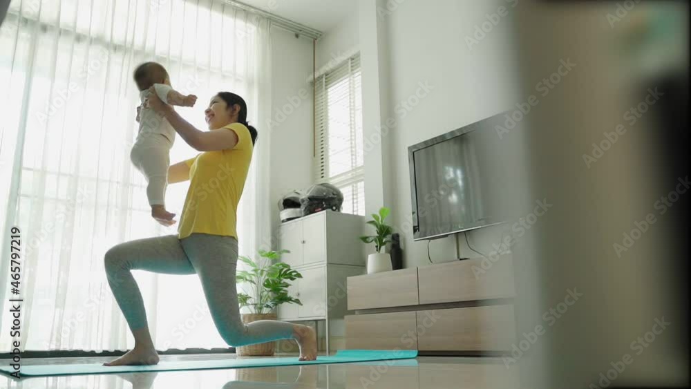 Asian Young mother doing physical yoga exercise with her baby boy at living room. Asian Young mother doing physical yoga exercise with her baby boy at living room.