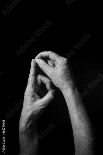 B+W image of hand demonstrating BSL sign language letter P isolated against black background