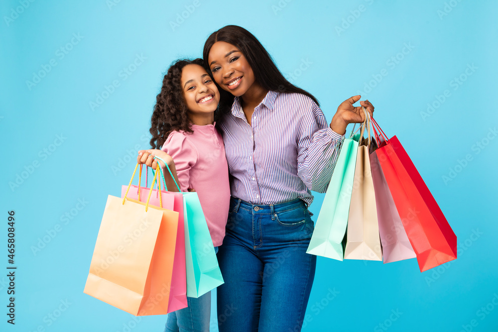 African American woman and girl posing with shopping bags African American woman and girl posing with shopping bags