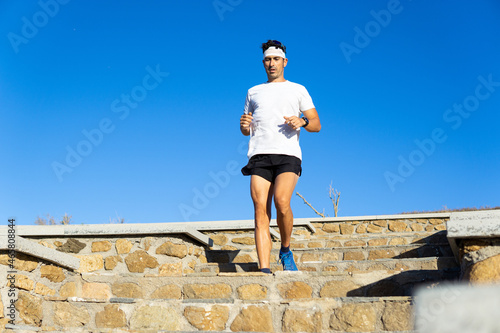 Young caucasian man exercising in the park running down on stairs