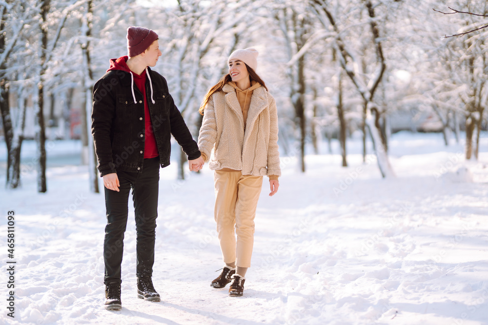 Love story young couple in winter. Happy couple walking and having fun at nature. Holidays, season, love and leisure concept. Love story young couple in winter. Happy couple walking and having fun at nature. Holidays, season, love and leisure concept.