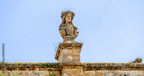 Bust on Palazzo del Sedile with pigeon defense in Bari, Italy