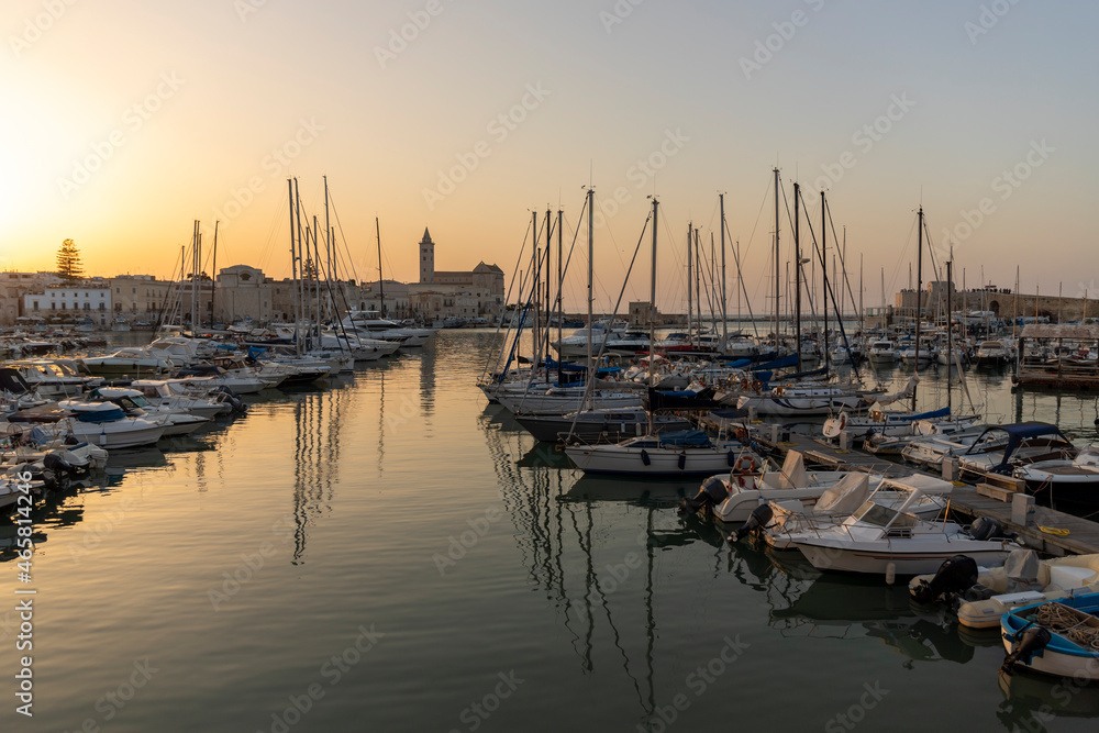 Trani city port at sunset in summer and the cathedral of Trani in background, Puglia, Italy.