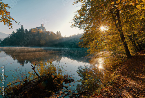 Beautiful autumn sunrise scenery of Trakošćan Castle on the hill by the lake in the forest at Croatia, county hrvatsko zagorje, nature background photo