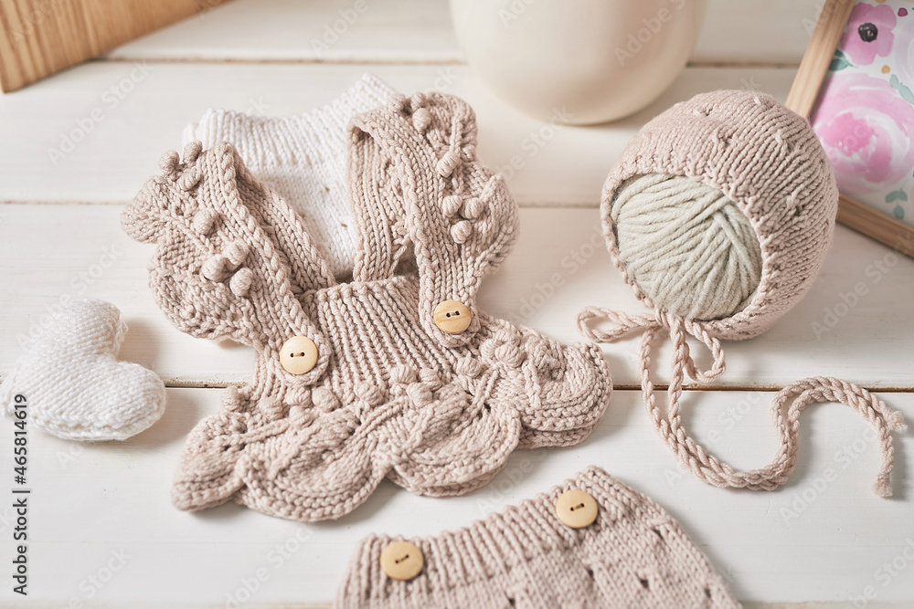Fototapeta premium Knitted kids clothes and accessories for knitting. Needlework and knitting. Hobbies and creativity. Knit for children. Handmade