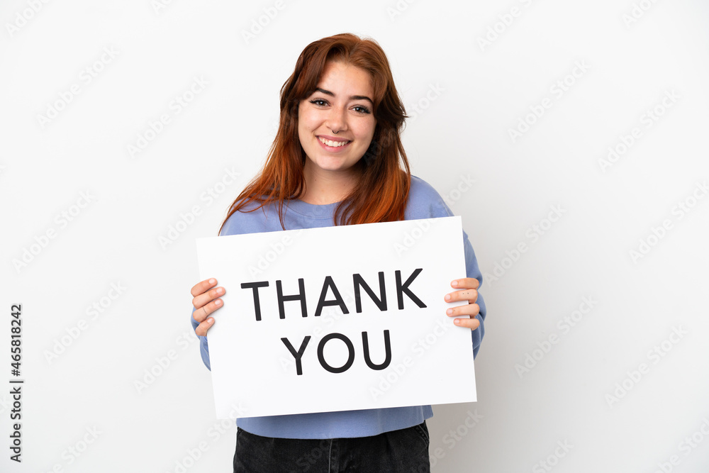 Young redhead woman isolated on white background holding a placard with text THANK YOU with happy expression Young redhead woman isolated on white background holding a placard with text THANK YOU with happy expression