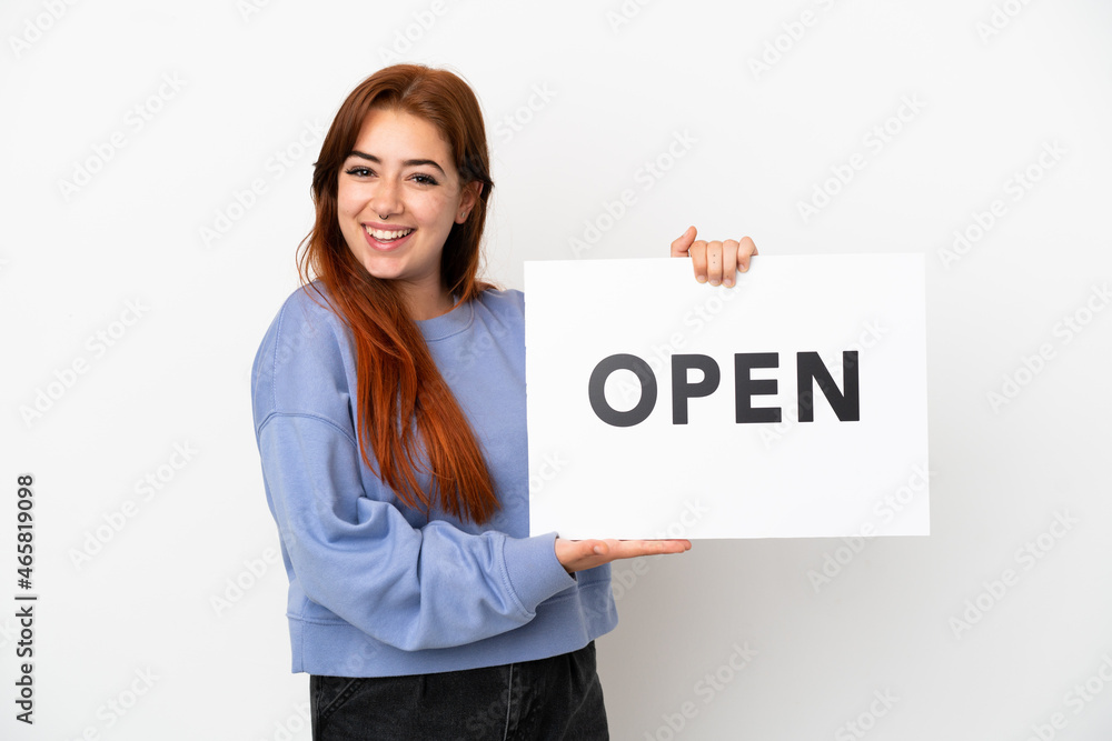 Young redhead woman isolated on white background holding a placard with peace symbol with happy expression Young redhead woman isolated on white background holding a placard with peace symbol with happy expression