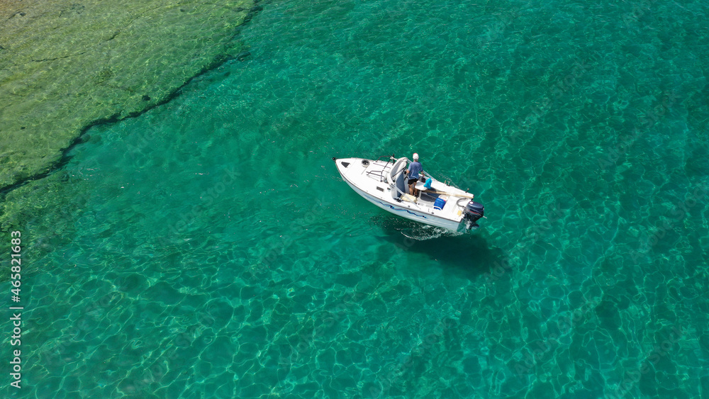 Aerial drone photo of small fishing boat cruising seascape in small Cycladic island of Schinoussa, Aegean Sea, Greece