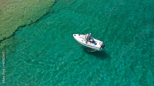 Aerial drone photo of small fishing boat cruising seascape in small Cycladic island of Schinoussa, Aegean Sea, Greece © aerial-drone