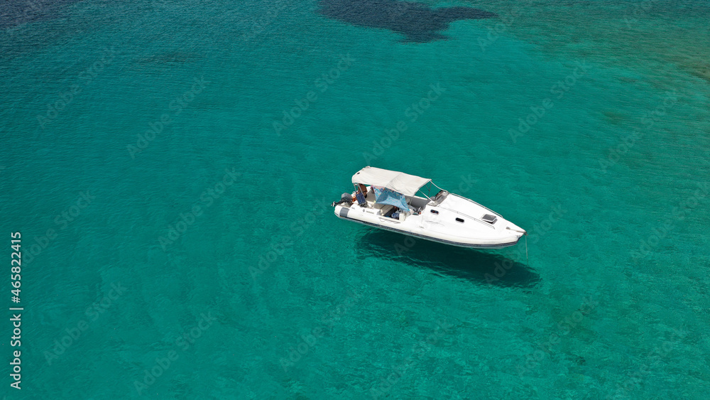 Aerial drone photo of inflatable boat anchored in tropical Caribbean turquoise bay with calm sea