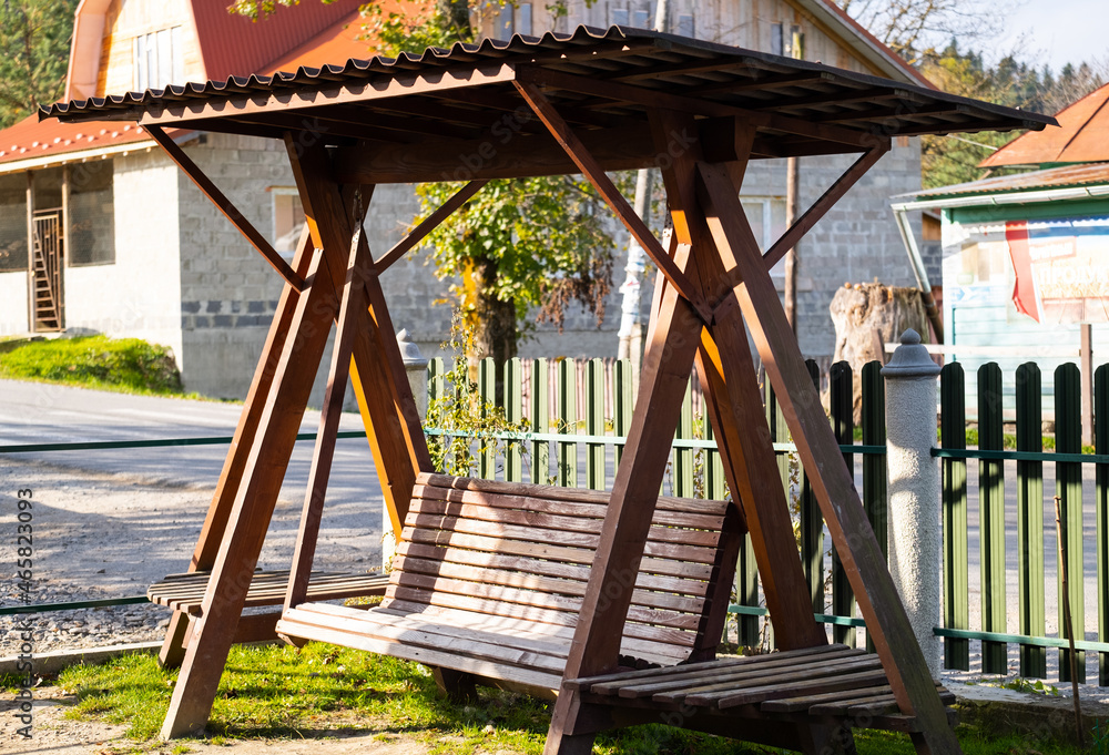 Wooden swing in the garden on the grass. Backyard. Countryside Wooden swing in the garden on the grass. Backyard. Countryside