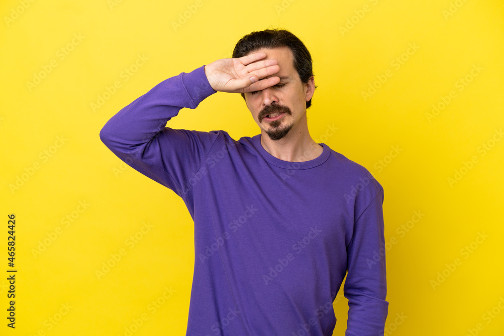 Young caucasian man isolated on yellow background with tired and sick expression Young caucasian man isolated on yellow background with tired and sick expression