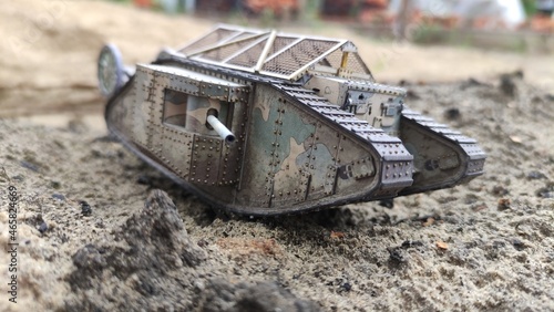 An English toy tank from the First World War. Mark I, the combat vehicle moves on the sand. Simple paper toys for children. Modeling, collecting, education, historical concepts