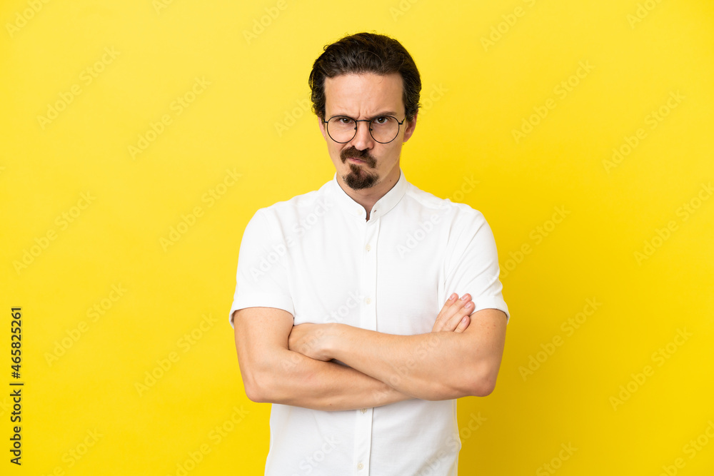 Young caucasian man isolated on yellow background with unhappy expression Young caucasian man isolated on yellow background with unhappy expression