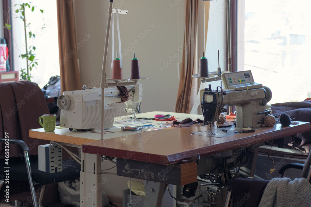 Used sewing machine and sewing tools in fashion atelier, selective focus Used sewing machine and sewing tools in fashion atelier, selective focus