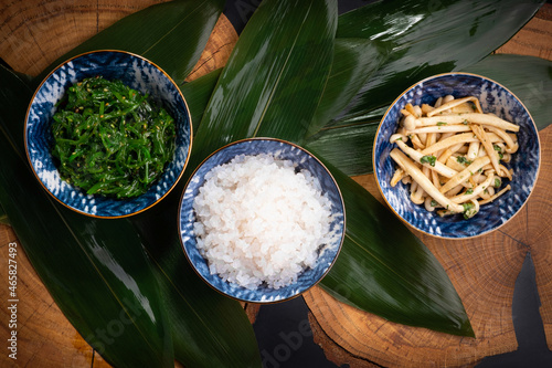 Shirataki rice or noodles, shimeji mushrooms and wakame in bowl on wooden table background. Konnyaku from konjac yam. Healthy japanese diet. Gluten and carbs free KETO food. Traditional oriental style photo
