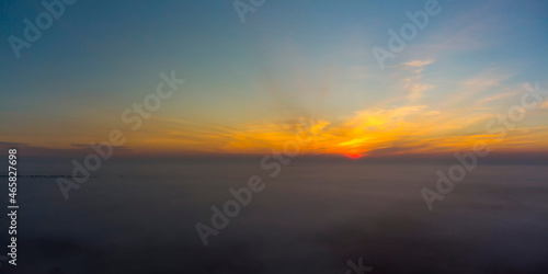 Panorama of sunrise. Blue sky with orange clouds.