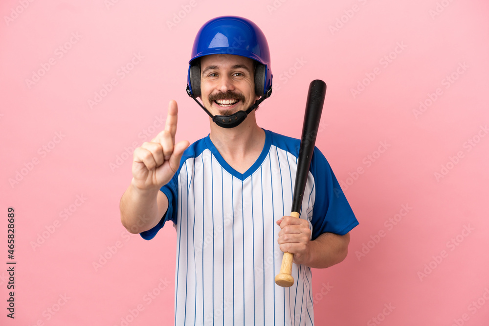 Young caucasian man playing baseball isolated on pink background showing and lifting a finger Young caucasian man playing baseball isolated on pink background showing and lifting a finger