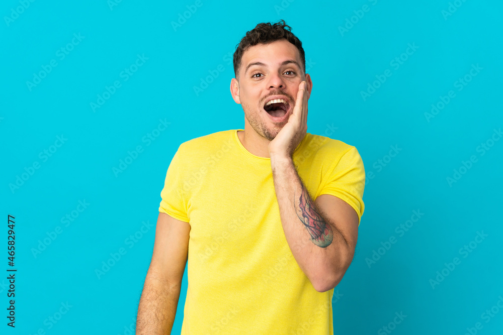 Young caucasian handsome man isolated on blue background with surprise and shocked facial expression Young caucasian handsome man isolated on blue background with surprise and shocked facial expression