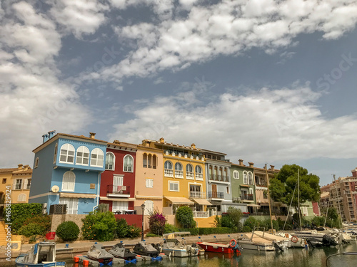 houses painted in different colors with moored boats and their reflection in the water