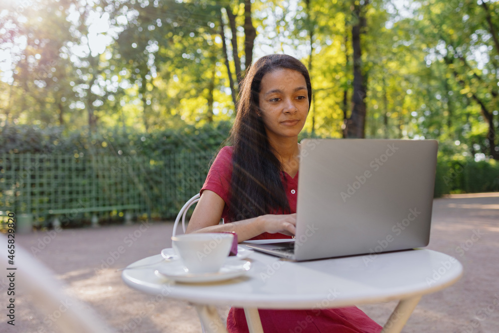 beautiful and young millennial african woman in a public place working on a laptop. african american businesswoman working in a park or doing online teaching. watching a webinar or creating content beautiful and young millennial african woman in a public place working on a laptop. african american businesswoman working in a park or doing online teaching. watching a webinar or creating content