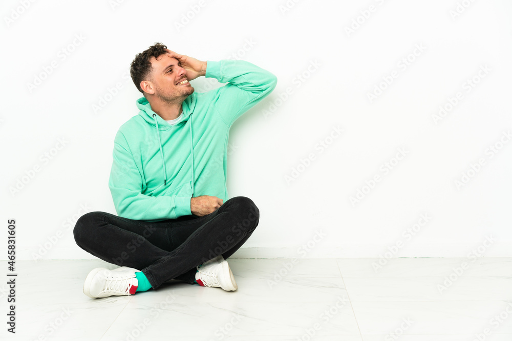 Young handsome caucasian man sitting on the floor has realized something and intending the solution Young handsome caucasian man sitting on the floor has realized something and intending the solution