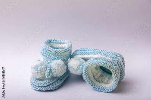 homemade knitted shoes for newborn boys on white background