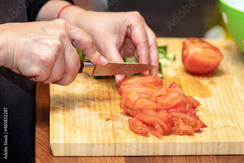 chopping tomato with a kitchen knife