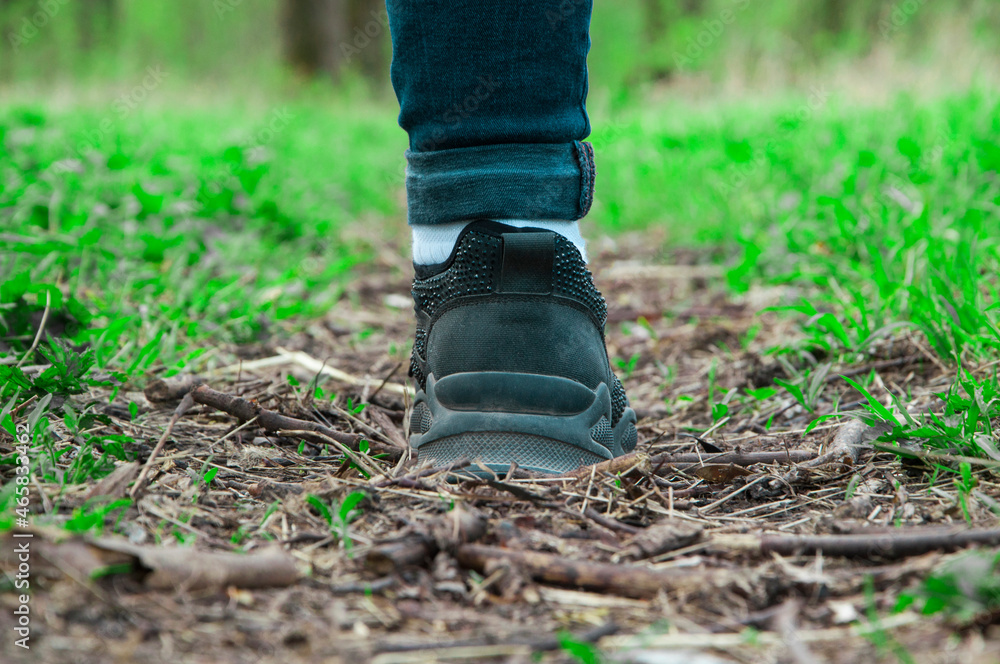 sneakers on the path. girl stands with her foot in the woods. illustration of travel. black shoes on a natural background. hiking concept sneakers on the path. girl stands with her foot in the woods. illustration of travel. black shoes on a natural background. hiking concept