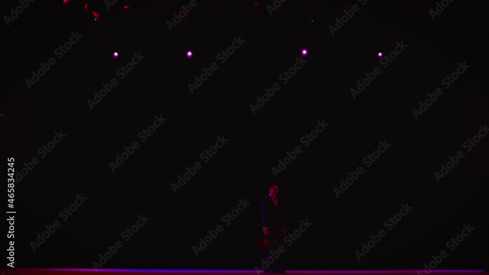 The showman appears on the scene from the dark. Showman on the stage of a large hall. The appearance of the magician on a rotating stage The showman appears on the scene from the dark. Showman on the stage of a large hall. The appearance of the magician on a rotating stage