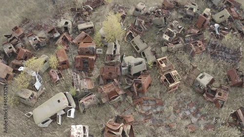 Aerial video. Old abandoned equipment that took part in the elimination of the accident. The village of Rassokha. Chernobyl. Rusty machinery.  photo