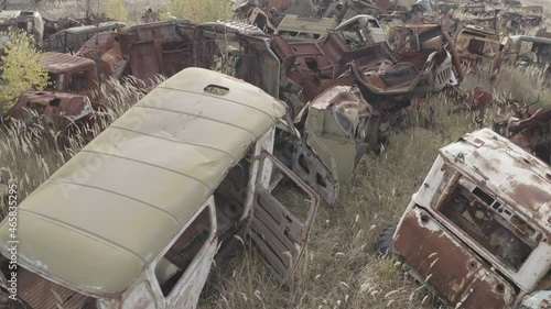 Aerial video. Old abandoned equipment that took part in the elimination of the accident. The village of Rassokha. Chernobyl. Rusty machinery.  photo