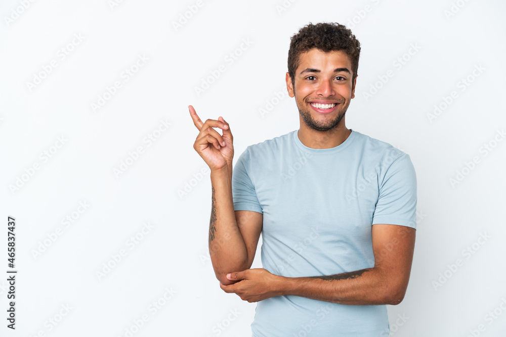 Young handsome Brazilian man isolated on white background happy and pointing up