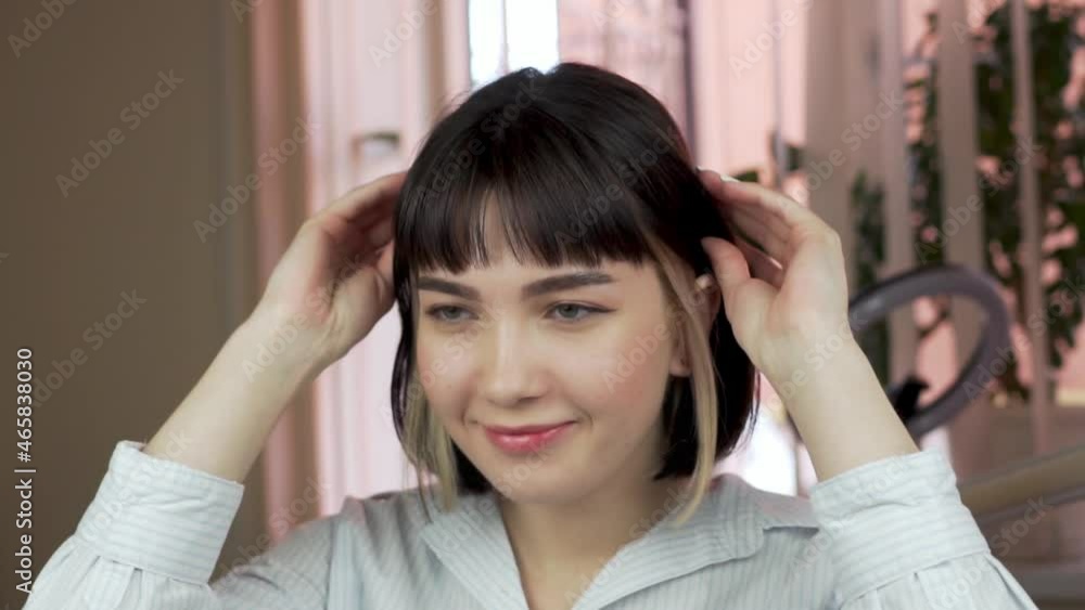 Portrait of Attractive Trendy Young Woman Adjusting Hair. Beautiful Female Face, Dark Hair with Trendy Modern Haircut and Coloring. Hair Care, Face Care. Portrait of Attractive Trendy Young Woman Adjusting Hair. Beautiful Female Face, Dark Hair with Trendy Modern Haircut and Coloring. Hair Care, Face Care.