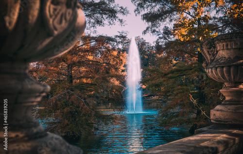 Jardín para relajarse en otoño junto a un lago , fuente de agua en medio del parque, chorro de agua en vertical saliendo del lago en otoño, lugar de relajación y de encuentro de paz en el parque