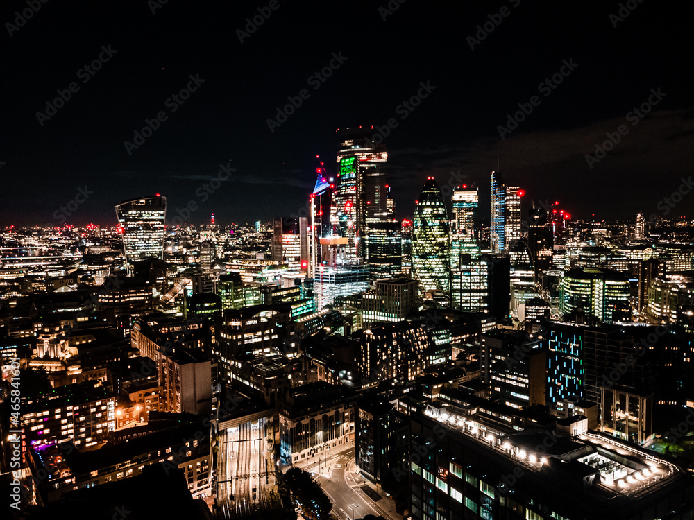 City of London one of the leading centres of global finance in night. Aerial photo over the big city at night